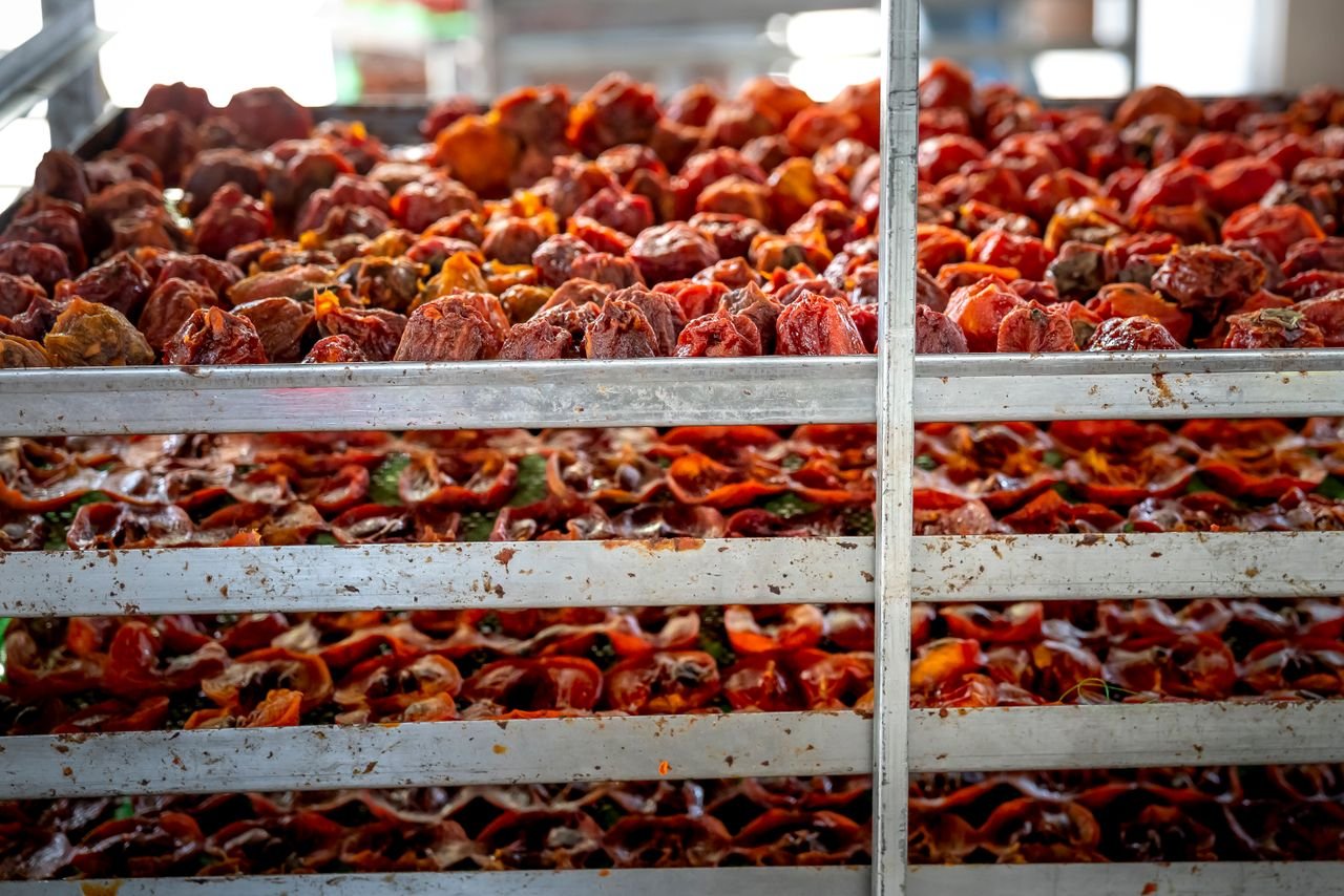 who-we-are Pile of tasty traditional Japanese sun dried persimmons placed on metal stall in in food market market on sunny day