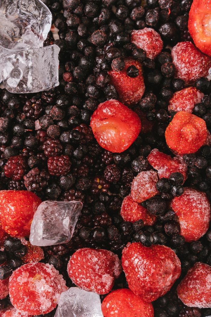 services-04 Close-up of frozen strawberries, blackberries, and blueberries with ice cubes.